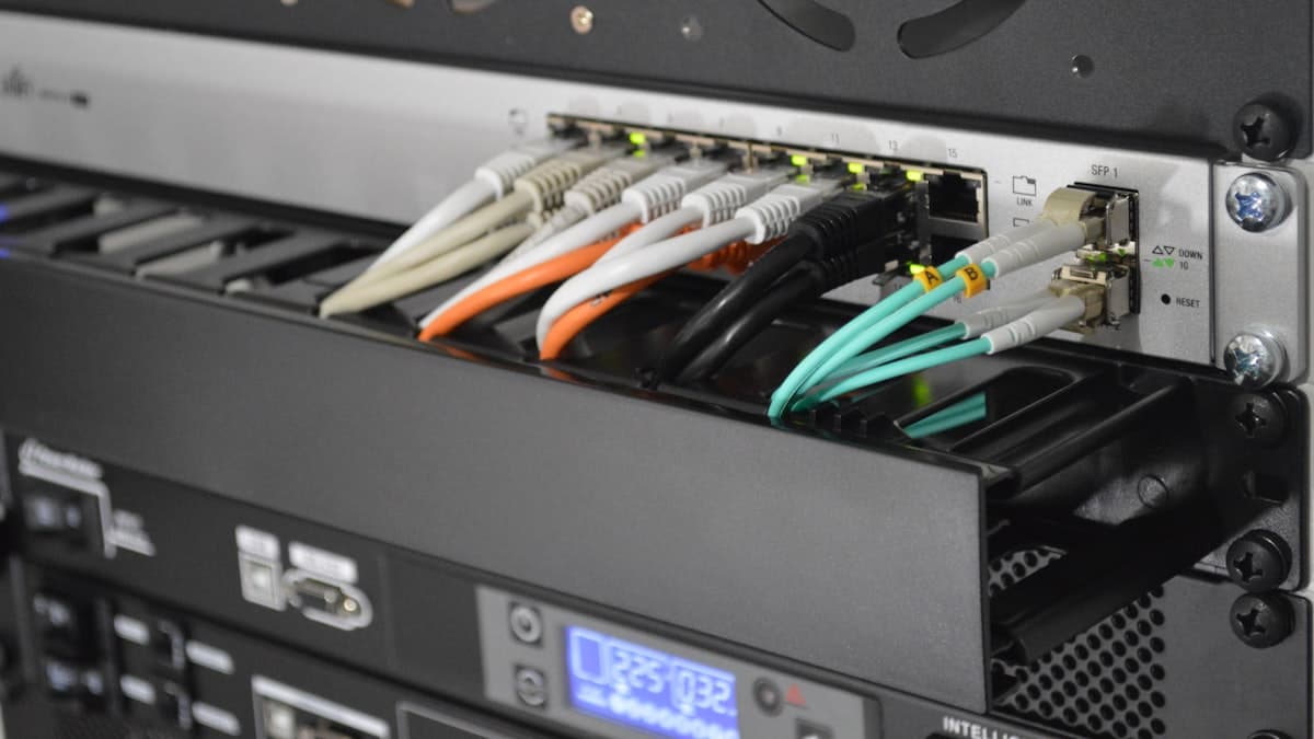 Rack-mounted enterprise switch with fibre and copper uplinks patched into its front ports