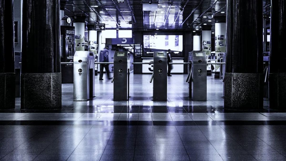 Access-controlled entry gates in a dark polished building concourse
