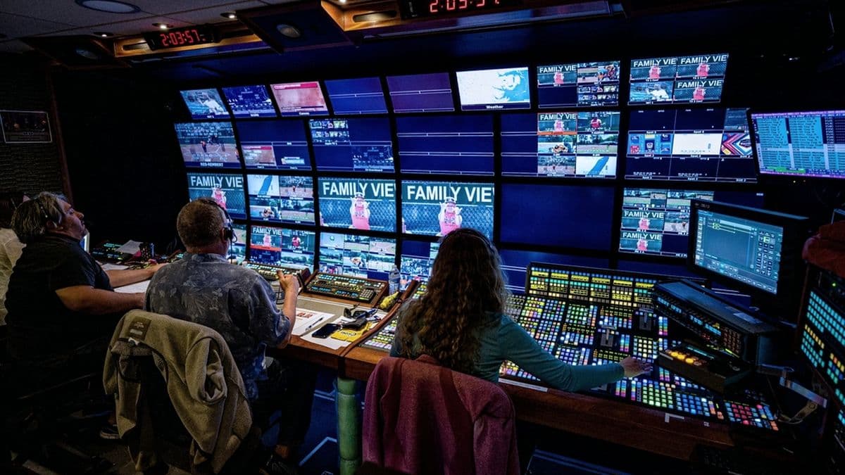 Operators watching a wall of live video feeds in a darkened monitoring room