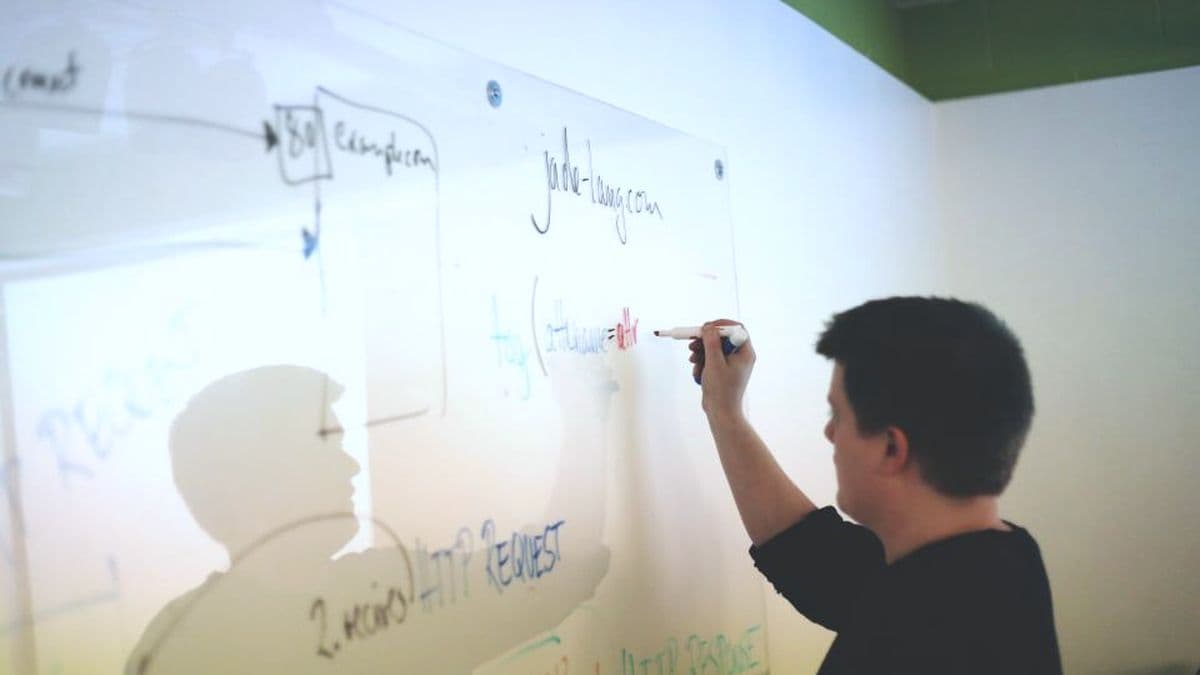 Advisor sketching out a plan on a glass writing wall