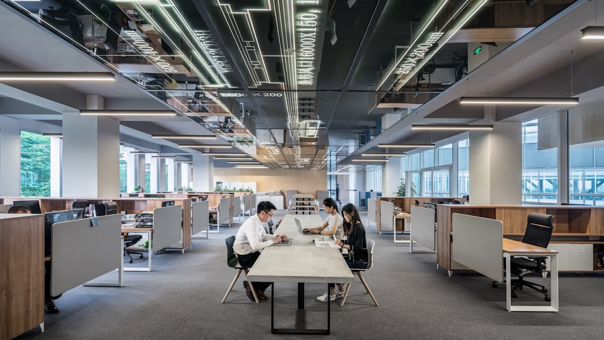 Open-plan corporate office floor lined with desks, monitors, and workstations