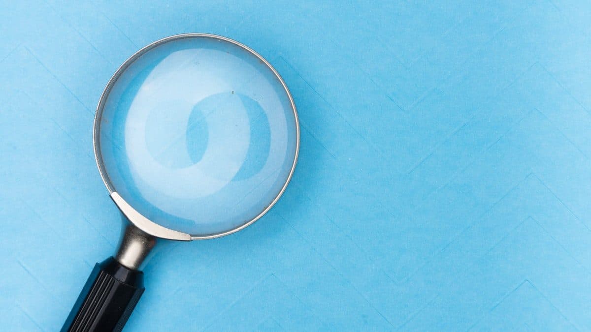 Magnifying glass resting on a pale blue surface